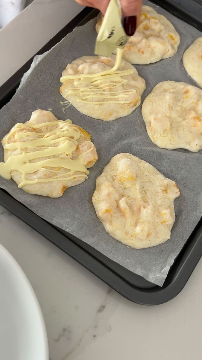 someone is spreading cheese on top of some tortilla shells in a baking pan