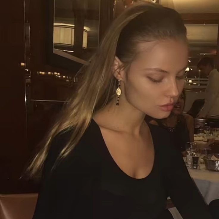 a woman sitting at a table with a plate of food in front of her