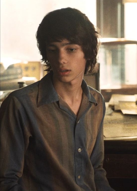 a young man sitting at a desk in front of a computer monitor with his eyes closed