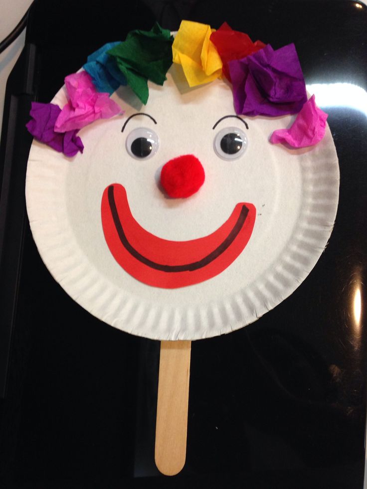 a paper plate with a clown face on it and a toothpick sticking out of it