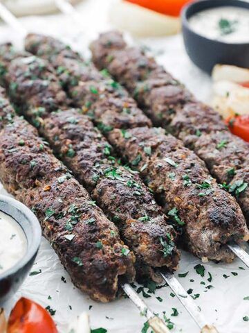 several skewers of meat and vegetables on a table