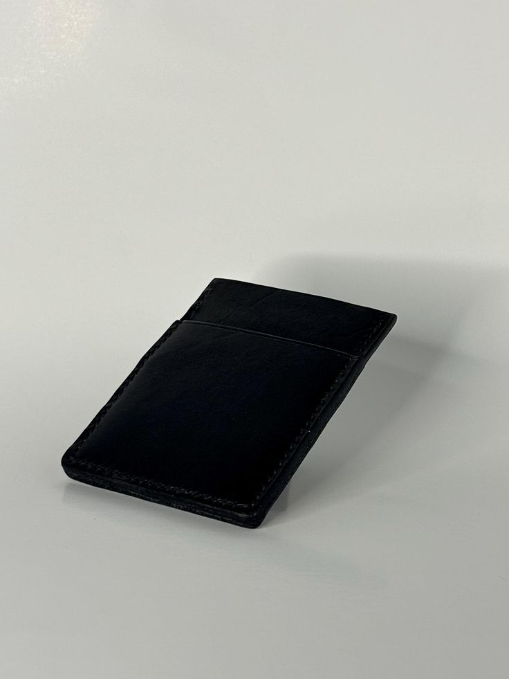 This sleek, handmade leather wallet is crafted from premium black leather, offering both style and durability. With its compact dimensions of 4 inches in length and 3 inches in width, it easily fits in your pocket while providing ample space for your essentials. The wallet features three carefully stitched pockets, perfect for holding cards, cash, and IDs securely. Designed for those who appreciate craftsmanship and simplicity, this minimalist wallet combines elegance with practicality, making it a timeless accessory for everyday use. Black Rectangular Wallet With Coin Pocket, Black Trifold Wallet With Coin Pocket For Everyday, Black Bifold Card Holder For Everyday Use, Black Trifold Wallet With Card Slots For Everyday, Black Trifold Card Holder With Interior Slots, Everyday Black Trifold Wallet With Card Slots, Business Trifold Wallet With Cell Phone Pocket, Classic Black Trifold Wallet With Card Slots, Black Rectangular Card Holder With Coin Pocket