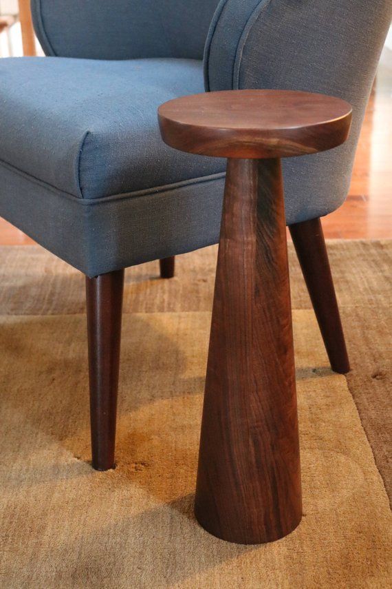 a blue chair sitting on top of a rug next to a wooden table in a living room