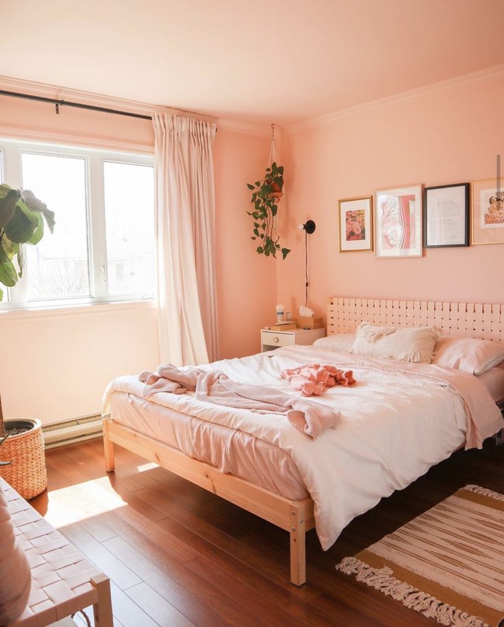 a bedroom with pink walls and wooden floors