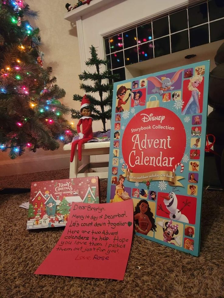 an elf's christmas calendar is on the floor next to a christmas tree