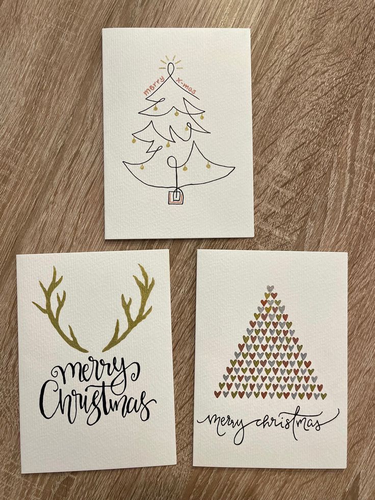 three handmade christmas cards on a wooden table