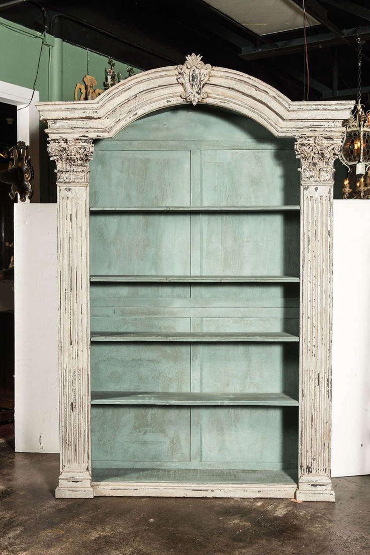 an old white bookcase with ornate carvings on it