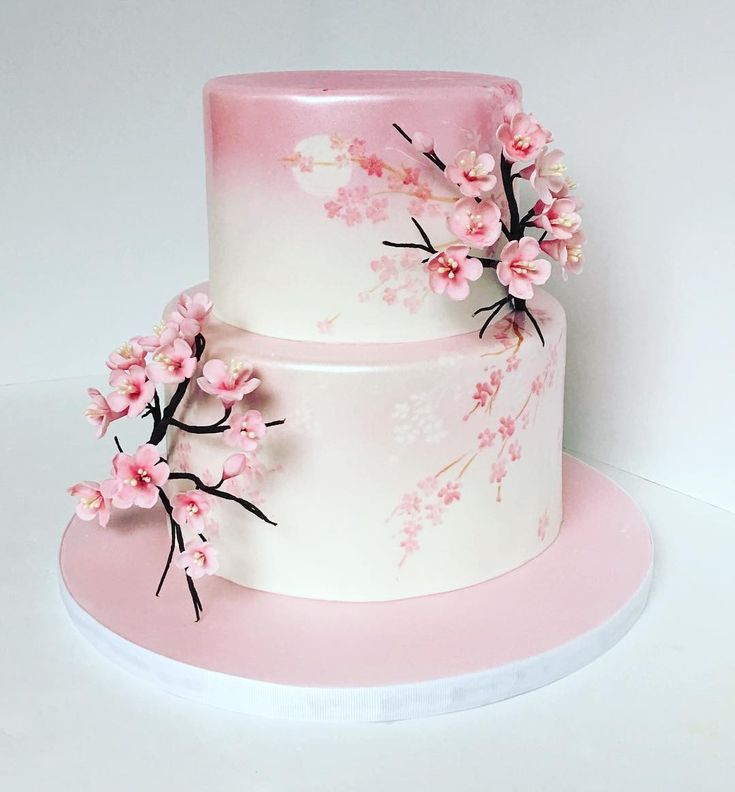 a three tiered cake with pink flowers on it