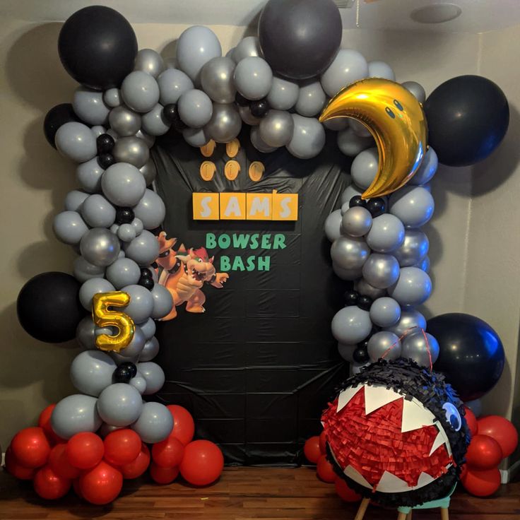 this is an image of a mickey mouse birthday party with balloons and streamers on the wall