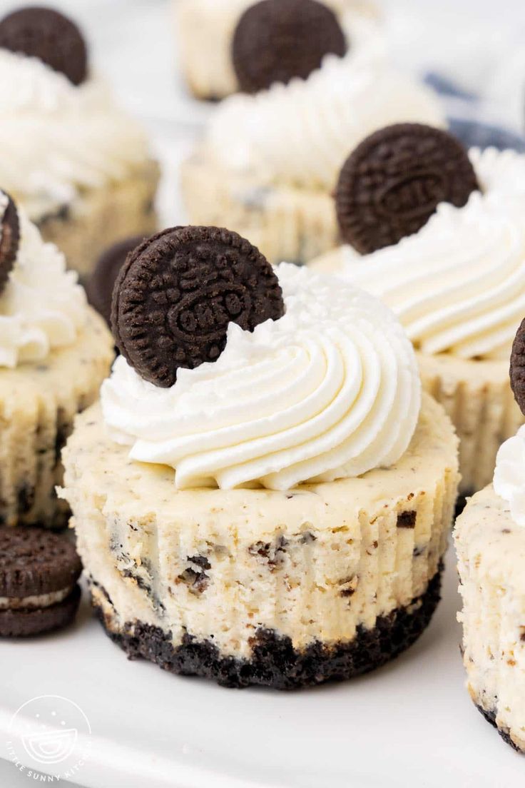 oreo cookies and cream cupcakes are on a white plate with chocolate chips