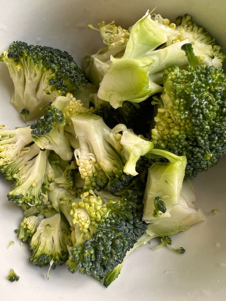 broccoli florets are in a white bowl