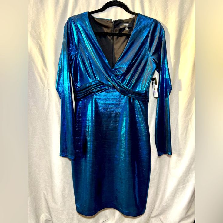 Turns Heads At Your Next Big Outing With This Electric Metallic Blue Mini Dress From Guess! Brand New With Tags From Macy’s Still Attached, Snag A Deal On This Unique And Vibrant Party-Ready Piece! Size 6, With A Stretchy Material That Leaves Room For Curves! :) Flattering Crisscross Details Under Chest/Around Waist V-Neck That Flatters Any Chest Size! Blue V-neck Holiday Mini Dress, Blue V-neck Party Dress, Blue Bodycon Dress For Party Season, Blue Long Sleeve Mini Dress For Holiday, Blue Bodycon Dress For Cocktail Party, Blue Mini Dress For Holiday Night Out, Blue Mini Dress For Night Out And Holiday, Blue Dressy Mini Dress For Party, Blue Mini Dress For Night Out During Holiday