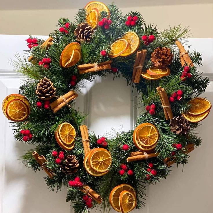 a christmas wreath with oranges, cinnamon and pine cones