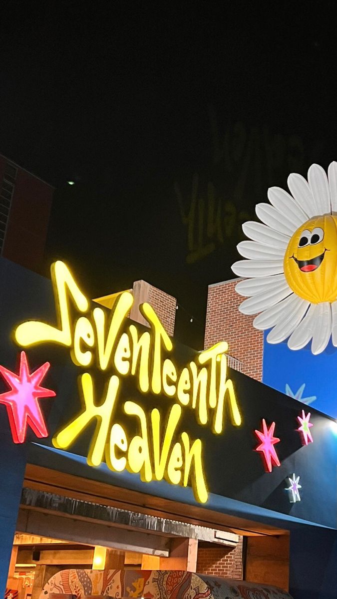 a neon sign that says seventh heaven with a smiley face on it