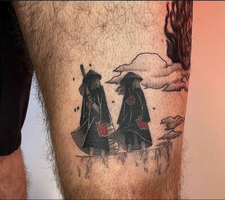 a man with a tattoo on his leg that has two black umbrellas in it