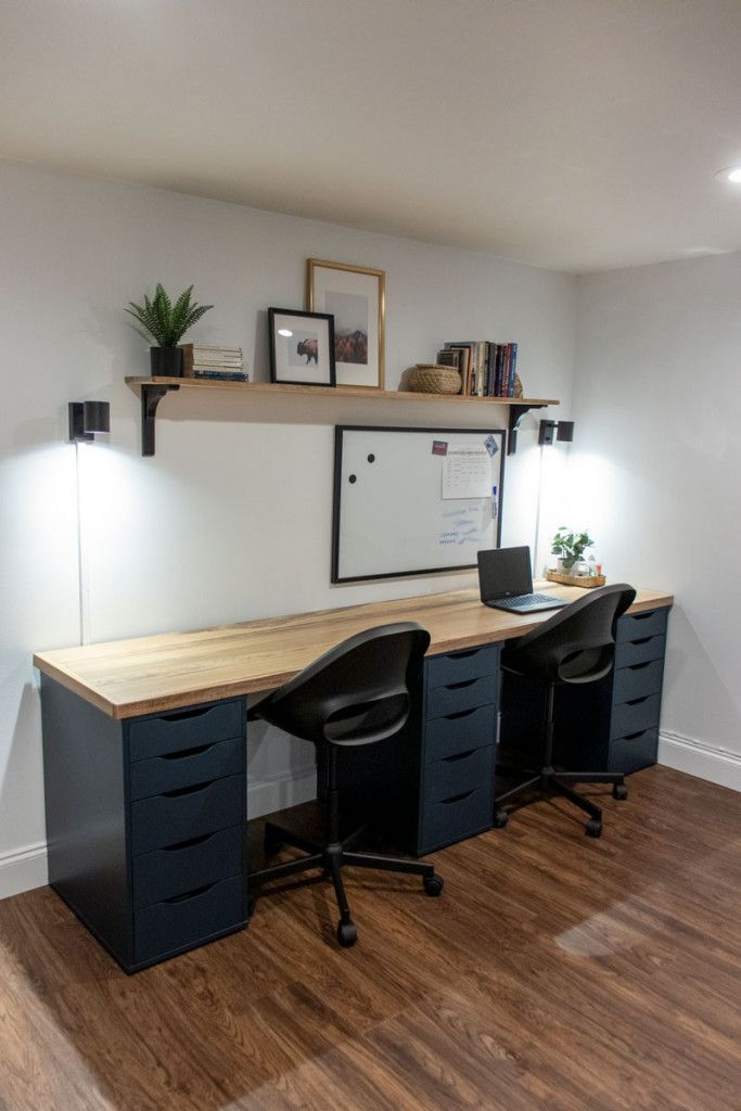 a desk with two chairs and a laptop on it in an office space that has hard wood flooring