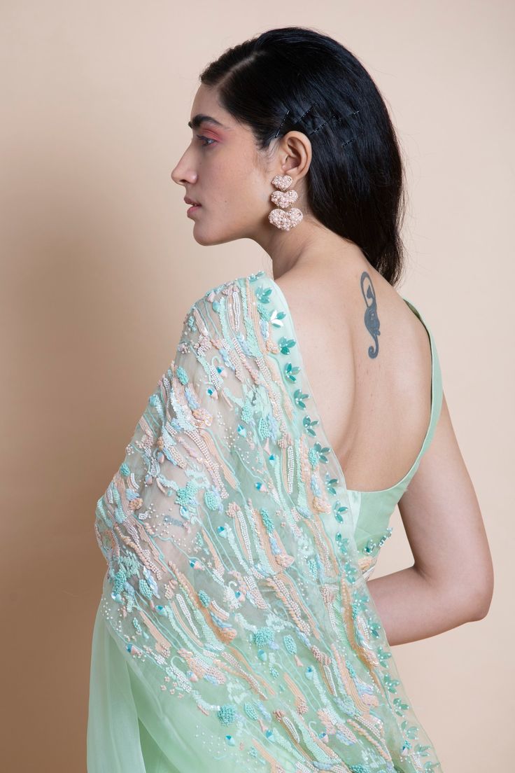 Editor's Note Featuring a neo mint hand-embroidered silk organza saree. This comes with matching blouse unstitched piece in chanderi and matching underskirt fabric in shantoon. Color: Mint Fabric: Silk Organza Length: Saree Length: 5.5m; Blouse Fabric: 1m Care: Dry Clean Only About the Designer Saksham & Neharicka make modernizing Indian wear with rich handwoven textiles, fresh intricate textures, chic and classic silhouettes, Saksham & Neharicka handcraft all designs to eternal perfection. Thei Green Pre-draped Saree With Intricate Embroidery For Festivals, Anarkali Organza Blouse With Floral Embroidery, Green Floral Embroidered Pre-draped Saree For Festivals, Green Tissue Silk Blouse With Dupatta, Green Chanderi Blouse With Sheer Dupatta, Pista Green Blouse With Sheer Dupatta For Reception, Party Chanderi Pre-draped Saree With Floral Embroidery, Green Organza Blouse With Traditional Drape, Green Organza Bollywood Blouse