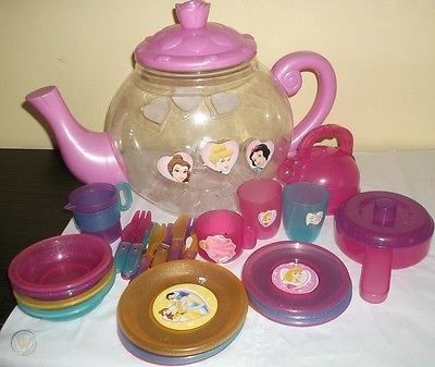 there is a teapot with princesses on it and many other toys around it