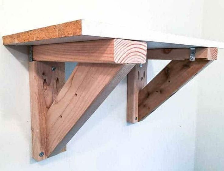 a wooden shelf with two brackets attached to it