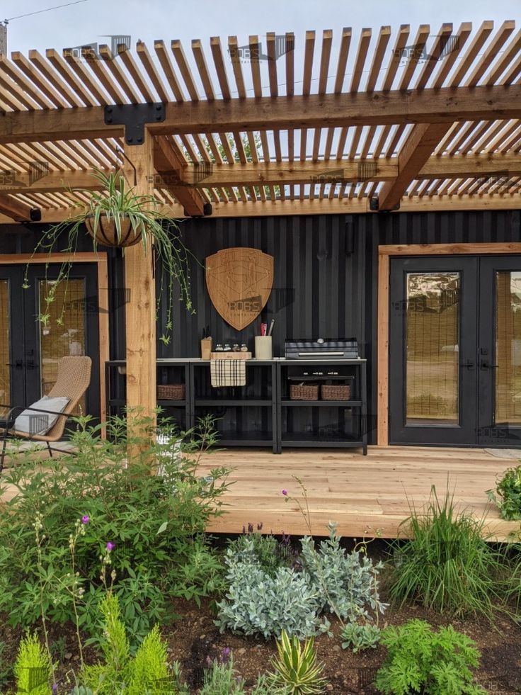 an outdoor kitchen and dining area is shown in this backyard garden design with wooden pergolan