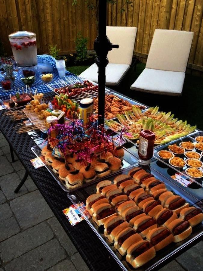 a table full of hot dogs and other foods