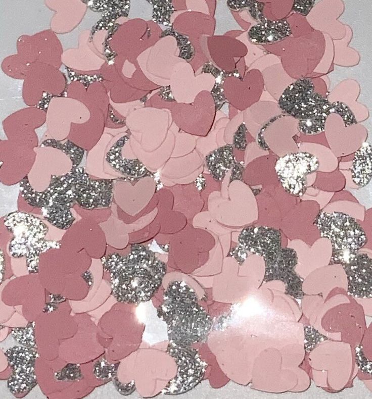 pink and silver heart confetti on a white table with lots of glitter hearts