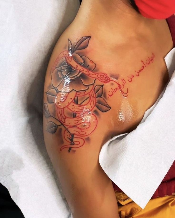 a woman laying on top of a bed covered in lots of tattoos with writing on her stomach