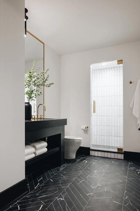 a black and white bathroom with marble flooring