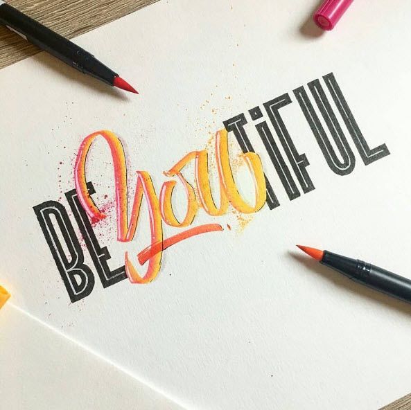 the word be joyful written in black and orange ink with crayons next to it