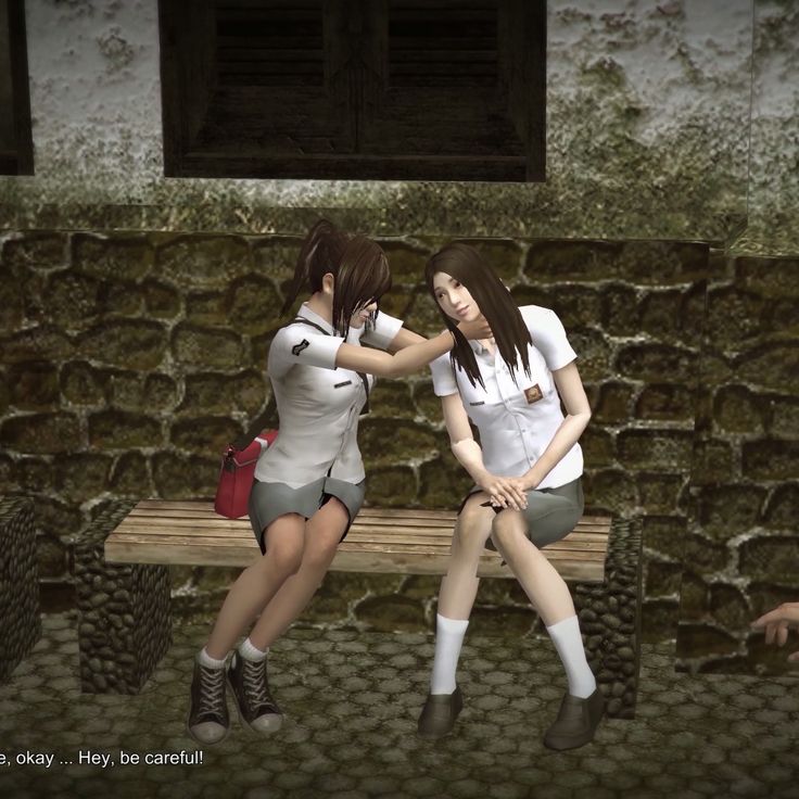 two young women sitting on a bench in front of a stone wall, one with her arm around the other's neck