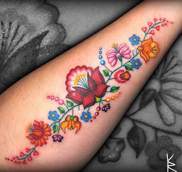 a woman's arm with colorful flowers on it