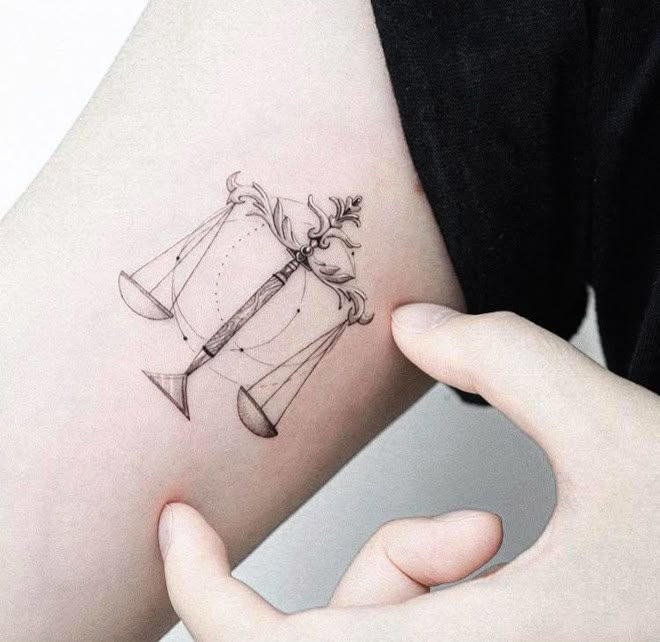 a woman's arm with a tattoo on it that has an hour and hourglass