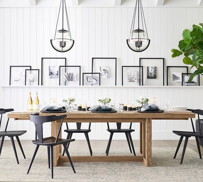 a dining room table with chairs and pictures on the wall