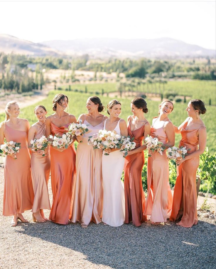 a group of women standing next to each other in front of a lush green field