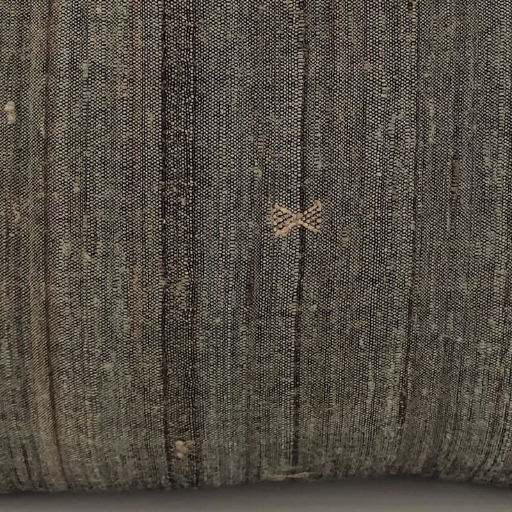 a brown pillow with an embroidered design on it