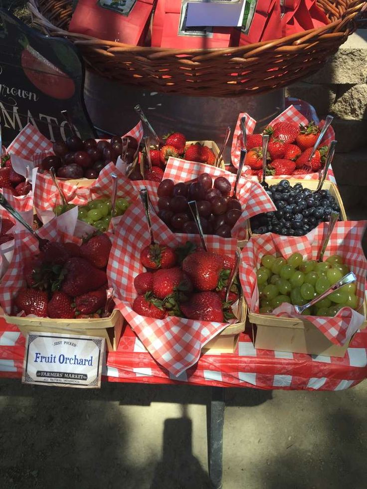 fresh fruit is on display in baskets at the farmer's market, including strawberries and grapes