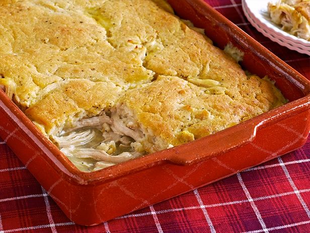 a casserole dish with chicken and cheese in it on a red checkered table cloth