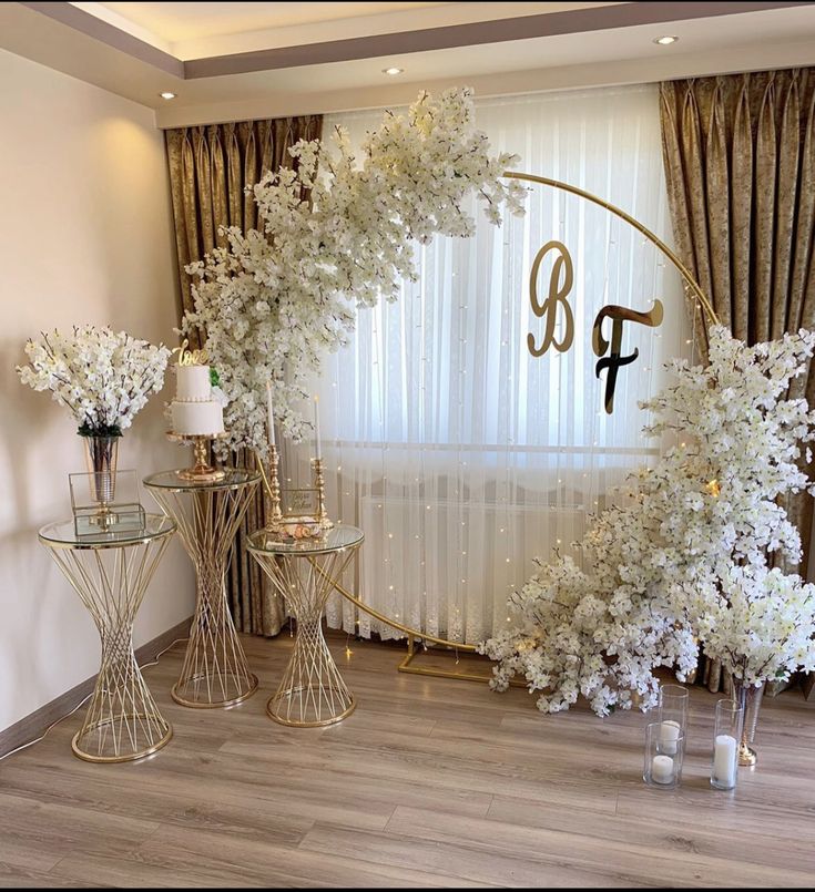 a room decorated with white flowers and gold accents