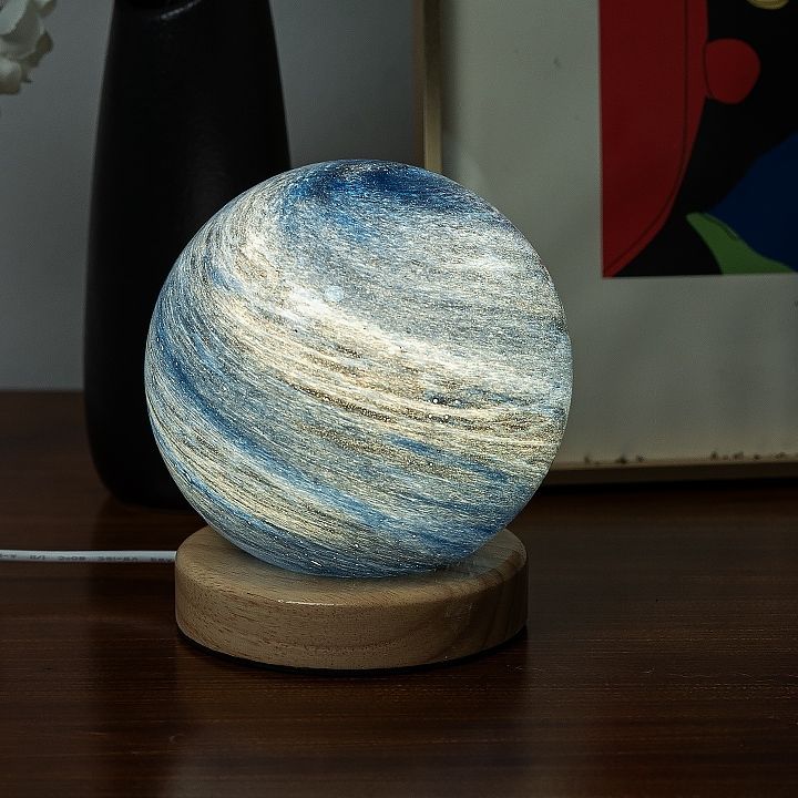 a blue and white marble sitting on top of a wooden stand