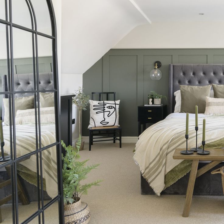 a bedroom with a bed, mirror and table in the corner on the floor next to it