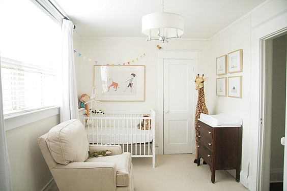 a baby's room with a giraffe print on the wall and a white crib