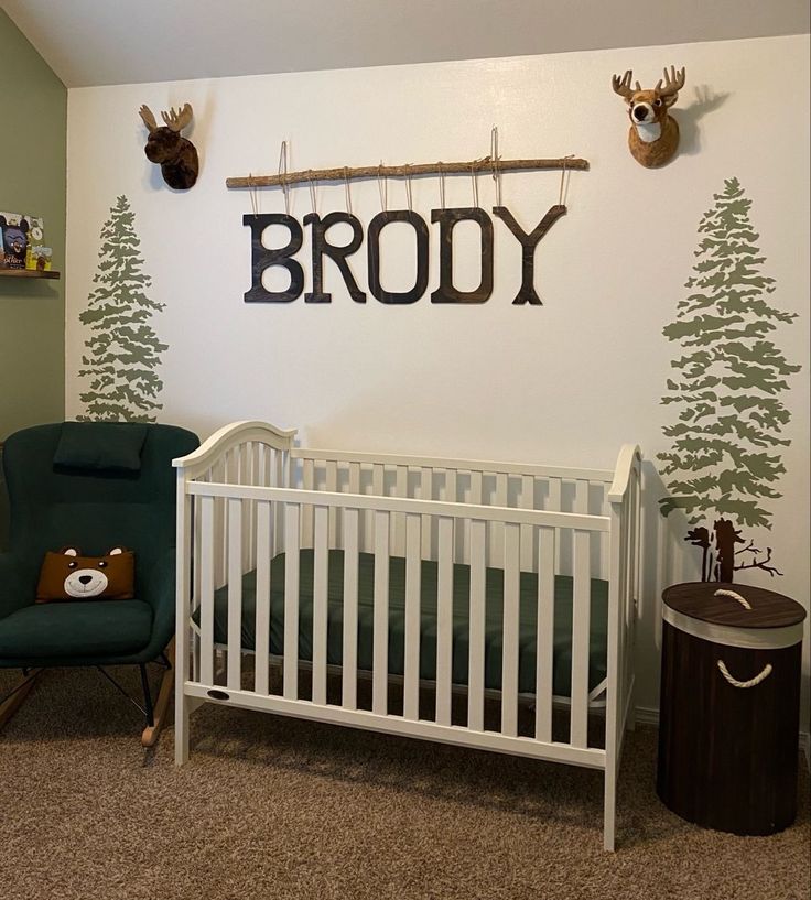 a baby's room with a crib, rocking chair and deer head on the wall