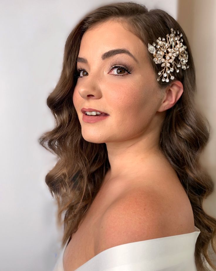 a woman with long hair wearing a white dress and a flower in her hair is looking off to the side