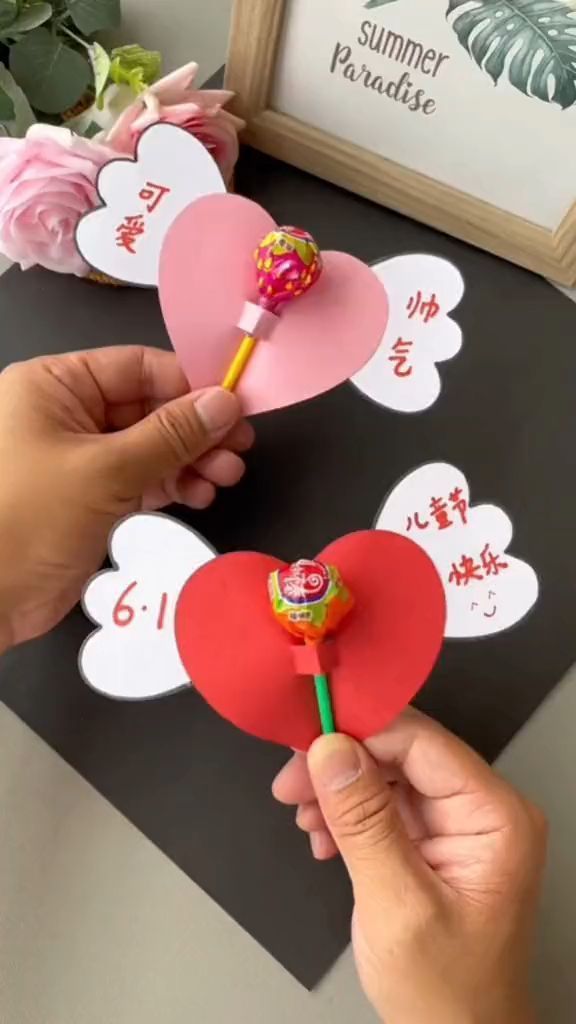 someone is holding a lollipop in front of a valentine's day card