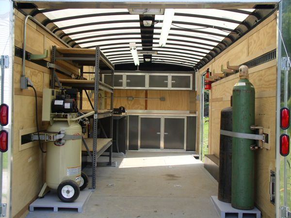 the inside of an enclosed vehicle with two green tanks and one red light at the back