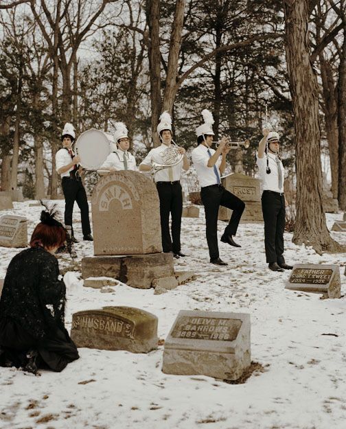 a group of people standing around a cemetery in the snow