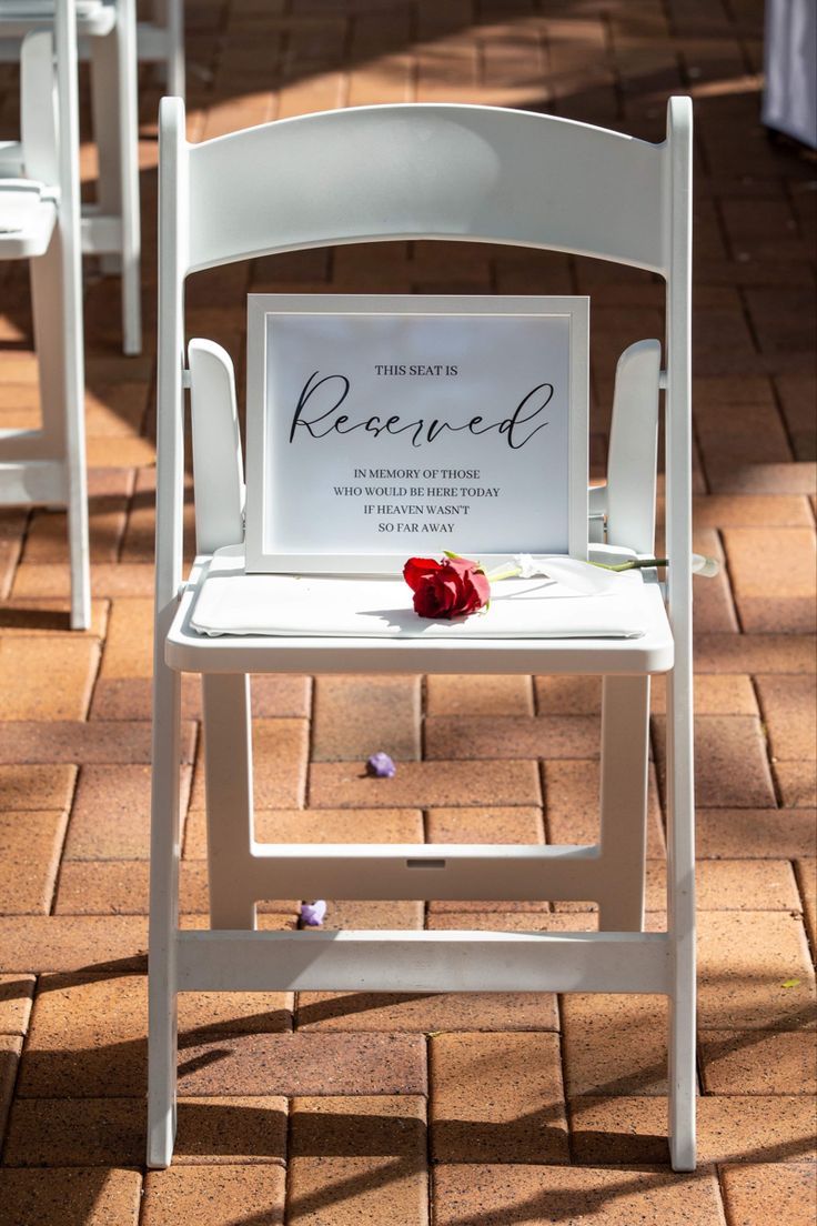 a white chair sitting on top of a brick floor next to a sign that reads record