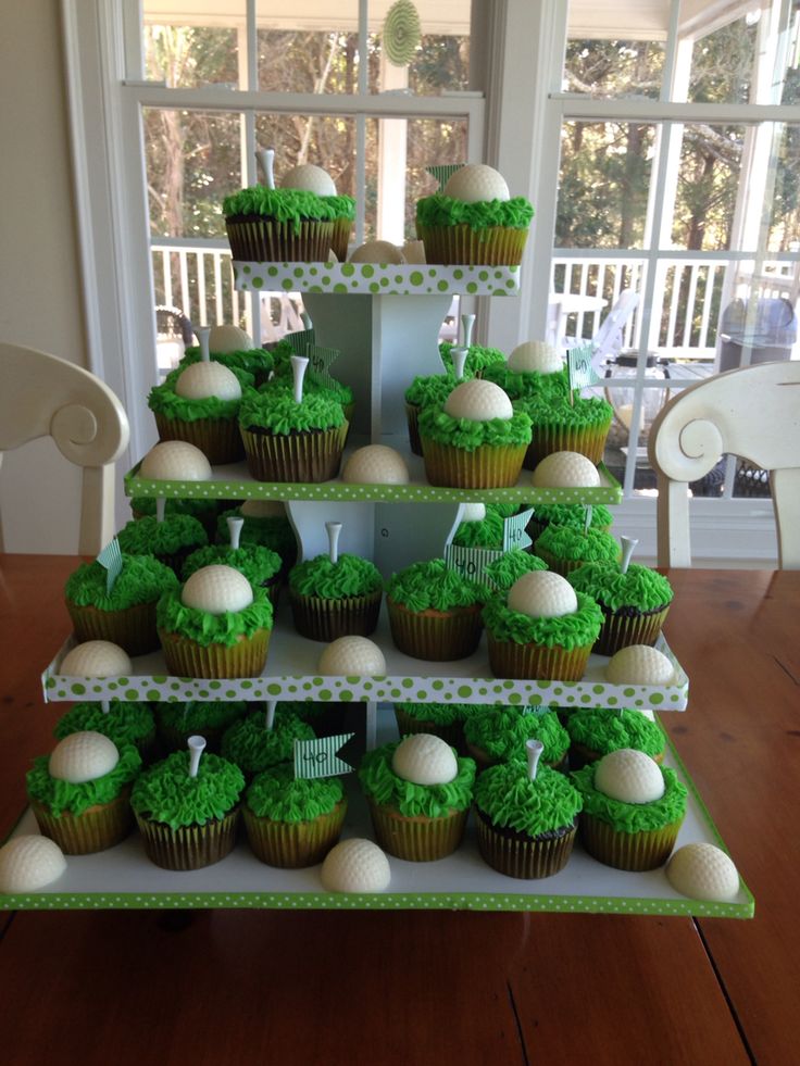 cupcakes are arranged in the shape of a golf course on a cake stand