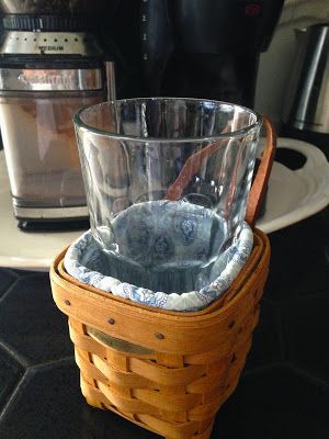 a glass sitting in a basket on top of a counter