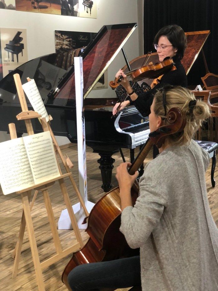 two women playing musical instruments in a room